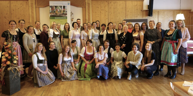 Gruppenfoto der Teilnehmer. 36 Frauen, die meisten im Dirndl, und ein Mann.