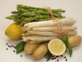 weißer und grüner Spargel, dekoriert mit rohen Kartoffeln und Zitrone