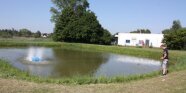 Foto eines Teichs mit einem Belüfter in Betrieb