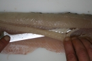 Messer schneidet in Stück Fisch