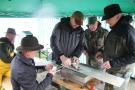 Einige Männer untersuchen einen Fisch auf einem Tisch unter einem Pavillon.