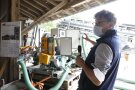 Ein Mann steht neben mehreren technischen Geräten. 