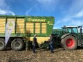 Ladewagen auf Feld mit zwei Männern davor