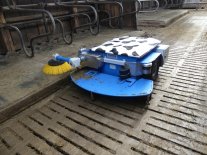 blauer Spaltenroboter "MultiRob" beim Reinigen von Spaltenboden und Liegeboxen