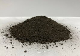 Schwarzes Pulver auf einem Haufen auf einer weißen Unterlage.