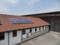 Dachansicht mit PV-Modulen, Wechselrichter an der Stallwand