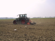 Schlepper fährt mit Kreiselegge übers Feld