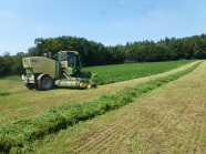 Landwirtschaftliche Maschine auf einem Feld am Waldrand