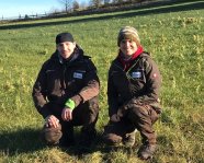 Zwei Personen in der Wiese kniend