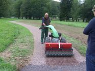 Mann walzt mit Gerät einen Feldweg