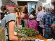 Eine Frau bindet Kränze per Hand aus Hopfendolden.