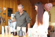 Zwei Personen in einm Raum mit verschiedenen Kaffeetüten und vollen Kaffeekannen