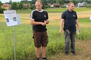 Zwei Personen auf dem Lupinenfeld mit Schild