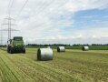 frisch gepresste, noch nicht gewickelte Ballen hinter Ballenpresse auf Feld