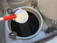 Probenahme von Molke mit Becher an langem Stiel