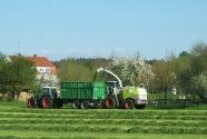 Landwirtschaftliche Fahrzeuge beim Grasmähen.