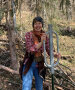 Eine lachende Frau bei Zäunungsarbeiten im Wald.