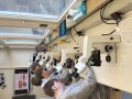 Jungs im Labor beim Blick unters Mikroskop.