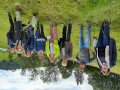 Die Jury: Acht Menschen stehen in einer abschüssigen Wiese