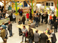 Mehr als 35 Menschen befinden sich auf einer Veranstaltung in einer Halle mit Infotafeln