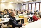 In einem Hörsaal sitzen viele Leute