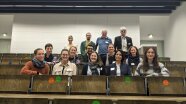 Gruppenfoto mit 14 Personen in einem Hörsaal.