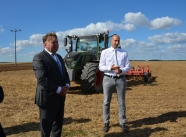 Betriebsleiter und Minister vor einem Traktor