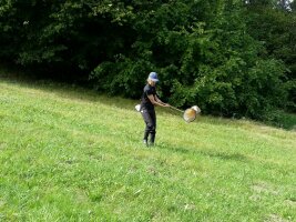 Person mit einem Kescher auf einer Wiese