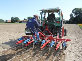 Person auf einem landwirtschftlichen Gerät auf einem Acker