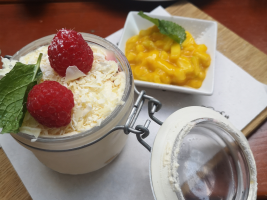 schön angerichtetes weißes Tiramisu mit einem Schälchen Mango-Kompott