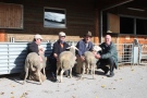 Schafe mit Männern vor einem Stall