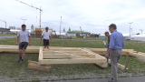 Personen begutachten Holzbalken-Konstrukt