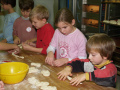 Kinder kneten an einem Tisch mit Teig