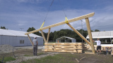 Holzbalken-Konstrukt wird von Kran angehoben