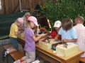 Kinder sitzen an einem Tisch und filzen Wolle