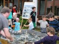 Mehrere Personen fischen in einem Teich mit Papierfischen