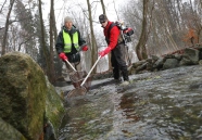 zwei Männer stehen in einem Bach und fangen Fische mit einem Kescher