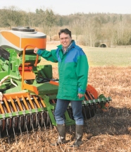 Mann steht an einem landwirtschaftlichen Gerät