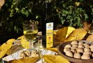 Auf einem Tisch steht ein Glas mit Walnussöl und daneben eine Flasche. 