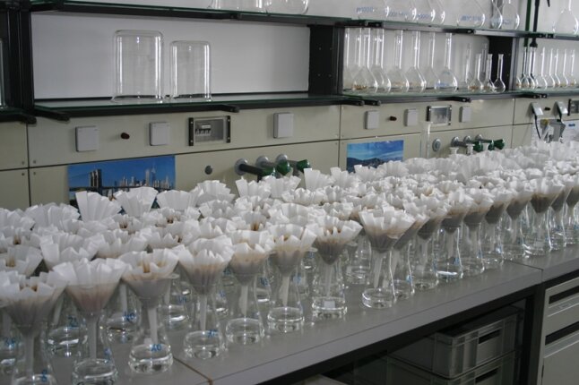 Labortisch voller Gläser mit Bodenproben