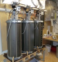 3 graue zylindrische Laborreaktoren zur Erzeugung von Biogas aus Grassilage